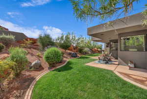View of green lawn with a patio area