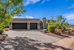 View of front of home featuring stucco siding, driveway, and a garage