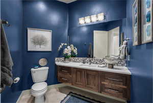 Half bathroom featuring decorative backsplash, vanity, and tile patterned floors