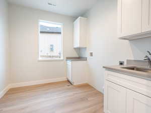 laundry room featuring cabinet space, washer hookup, LVP flooring, and electric dryer hookup