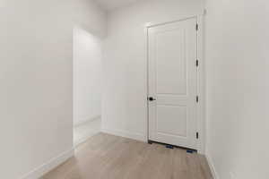 Corridor with baseboards and light wood-style flooring