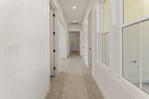 Hallway featuring light carpet and recessed lighting