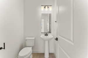 Bathroom featuring toilet and wood finished floors