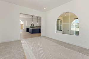 Unfurnished living room featuring light carpet and recessed lighting