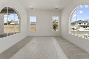 Spare room featuring light colored carpet, recessed lighting, and healthy amount of natural light