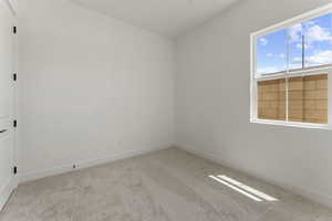 Empty room with light carpet and baseboards