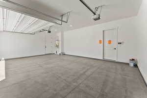 Garage featuring baseboards and a garage door opener