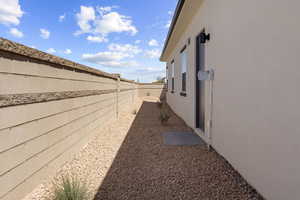 View of side of property with a fenced backyard and stucco siding