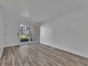 Spare room featuring light wood-type flooring and baseboards