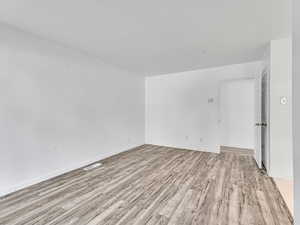 Unfurnished room with light wood finished floors and baseboards