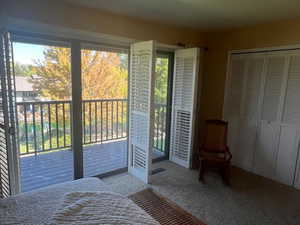 Bedroom with access to exterior, carpet flooring, and a closet