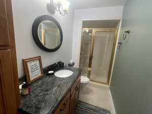 Full bath featuring a shower stall, vanity, light tile patterned floors, and a chandelier