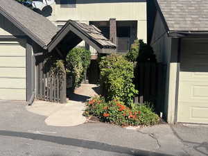 View of exterior entry with a shingled roof