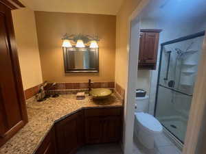 Bathroom featuring a stall shower, vanity, and tile patterned flooring