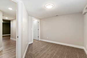 Basement with a textured ceiling, carpet flooring, and recessed lighting