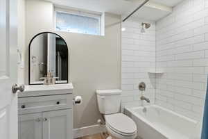 Full bath featuring shower / tub combo, vanity, and wood finished floors