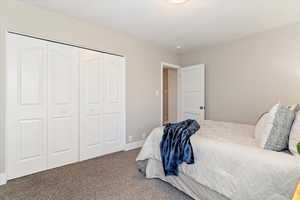 Carpeted bedroom with a closet and baseboards