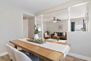 Dining space with wood finished floors and ceiling fan