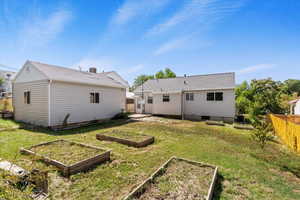 Rear view of property featuring a patio area and a vegetable garden