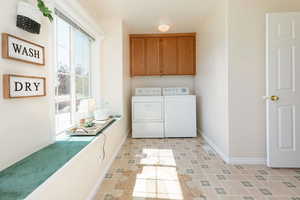 Washroom featuring cabinet space and washing machine and dryer