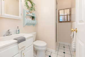 Full bath featuring vanity, a stall shower, and light tile patterned floors