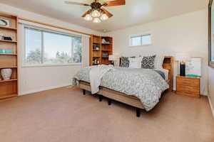 Primary Bedroom featuring light carpet and ceiling fan