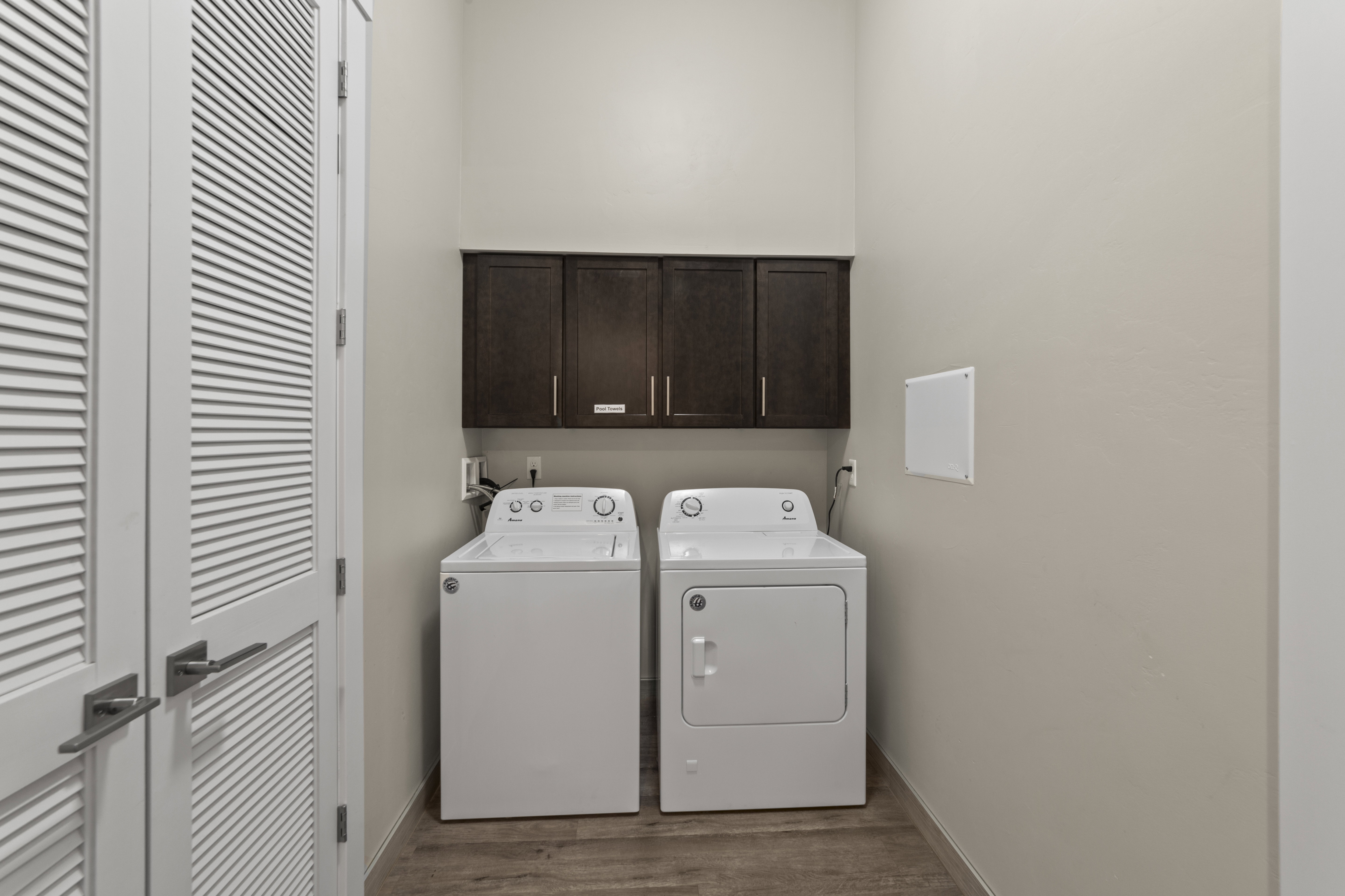 Laundry room with cabinet space, independent washer and dryer, and wood finished floors