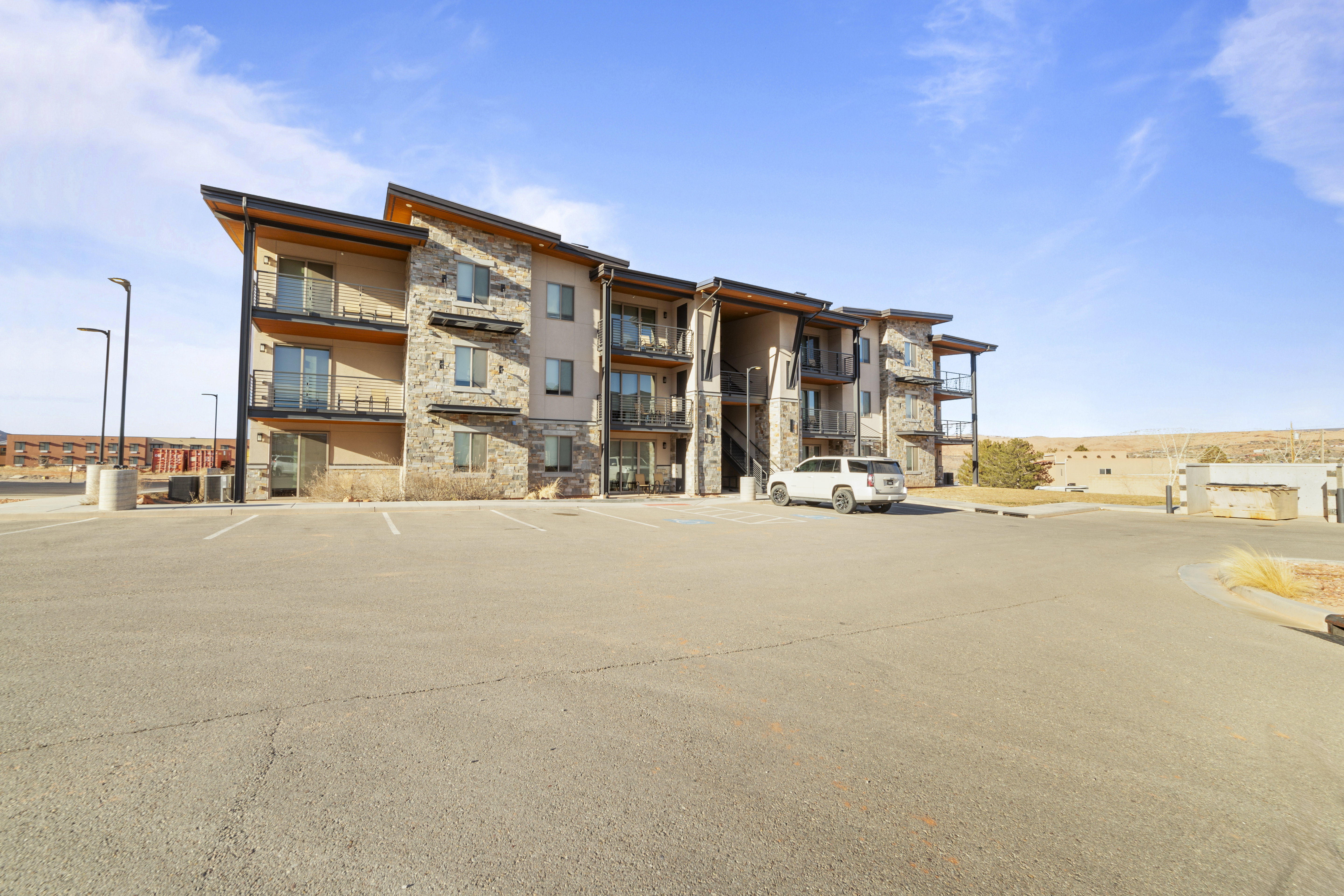 View of apartment building / complex featuring uncovered parking