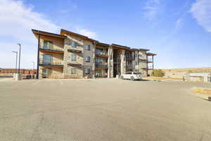 View of apartment building / complex featuring uncovered parking