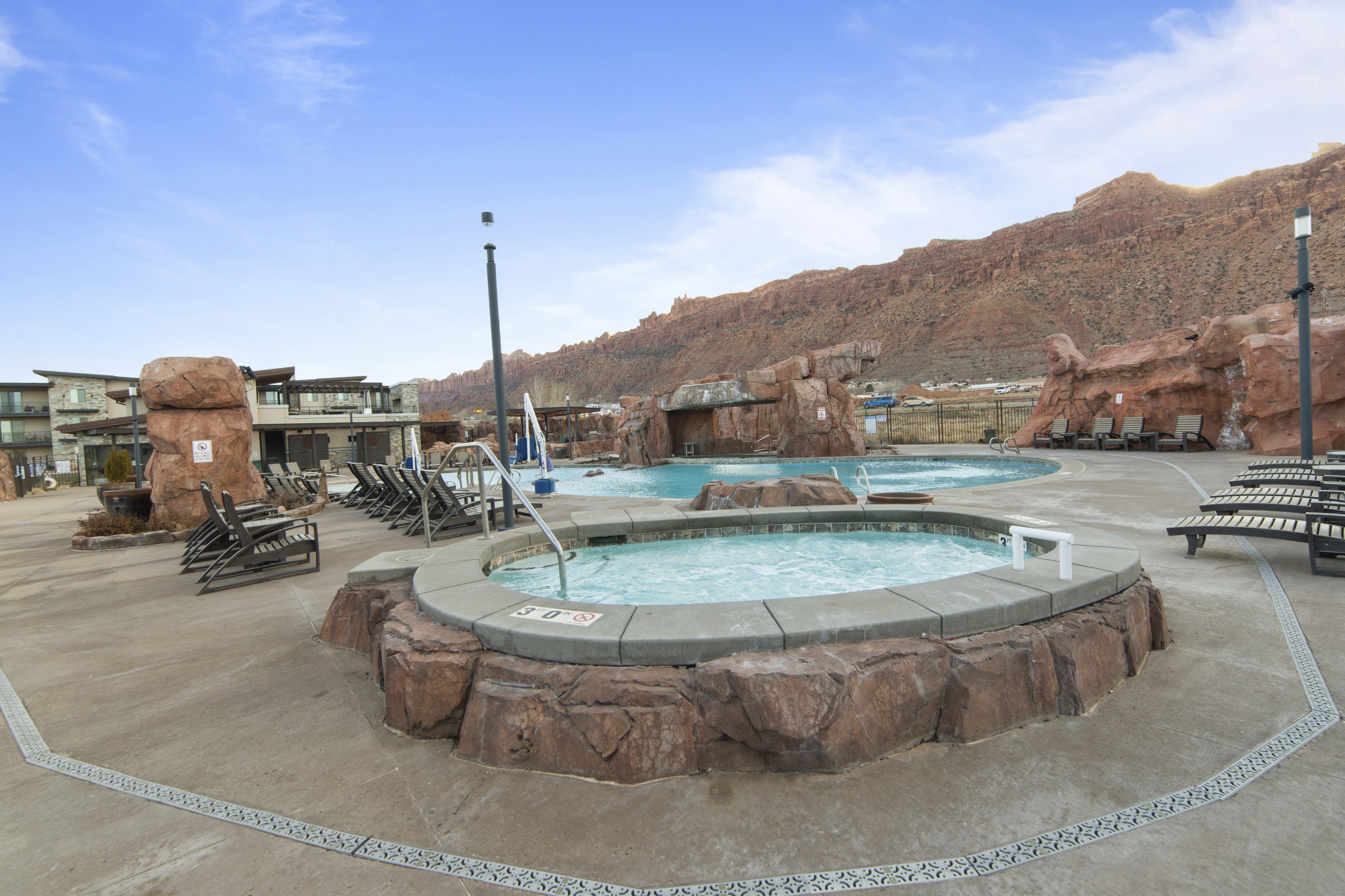 Community pool featuring a hot tub, a patio, and a mountain view