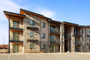 View of apartment building / complex with uncovered parking