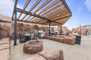 View of patio / terrace with outdoor dining space, a pergola, area for grilling, and an outdoor fire pit