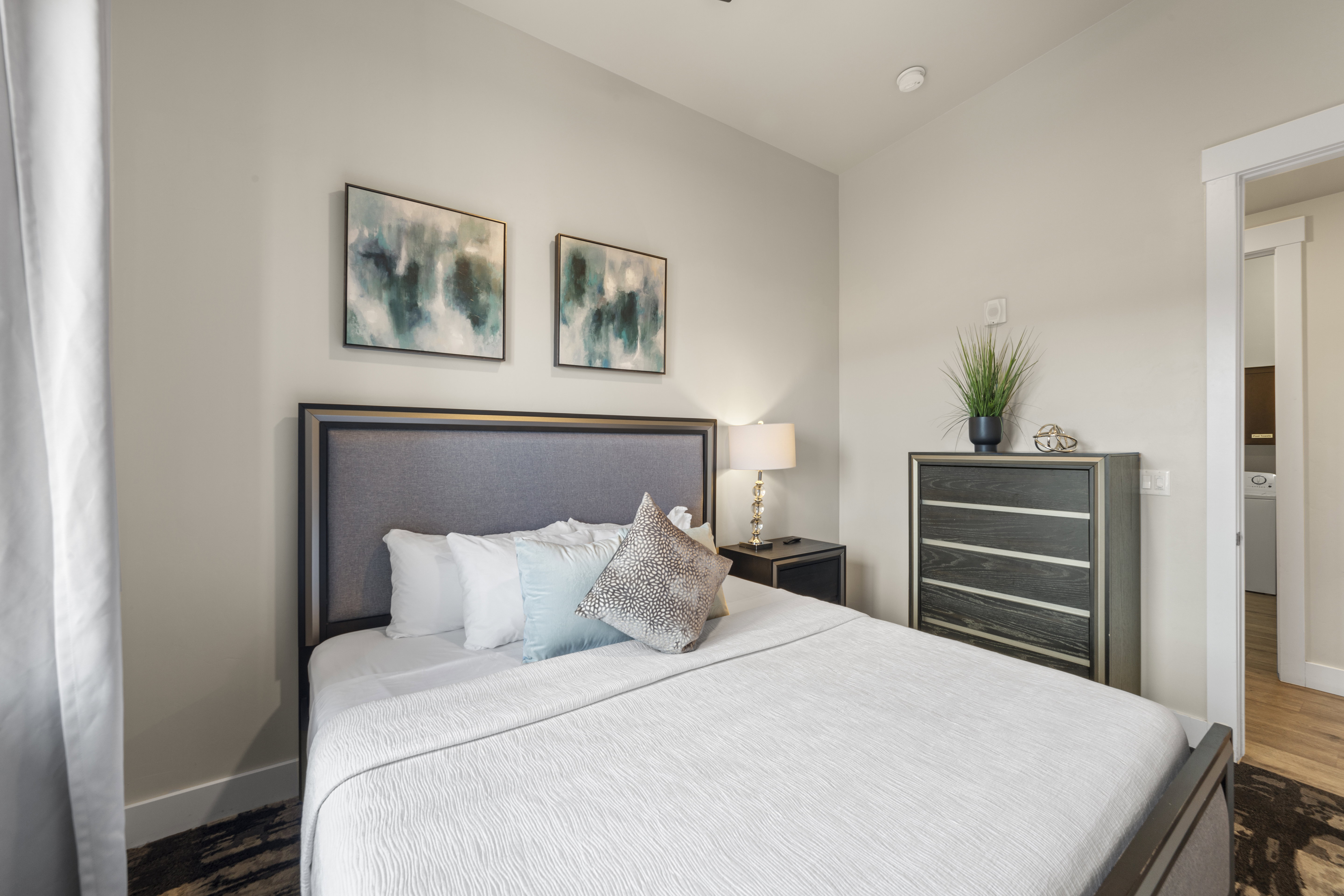 Bedroom featuring wood finished floors, washer / clothes dryer, and wine cooler