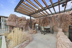 View of patio with a pergola, outdoor dining space, and a grill