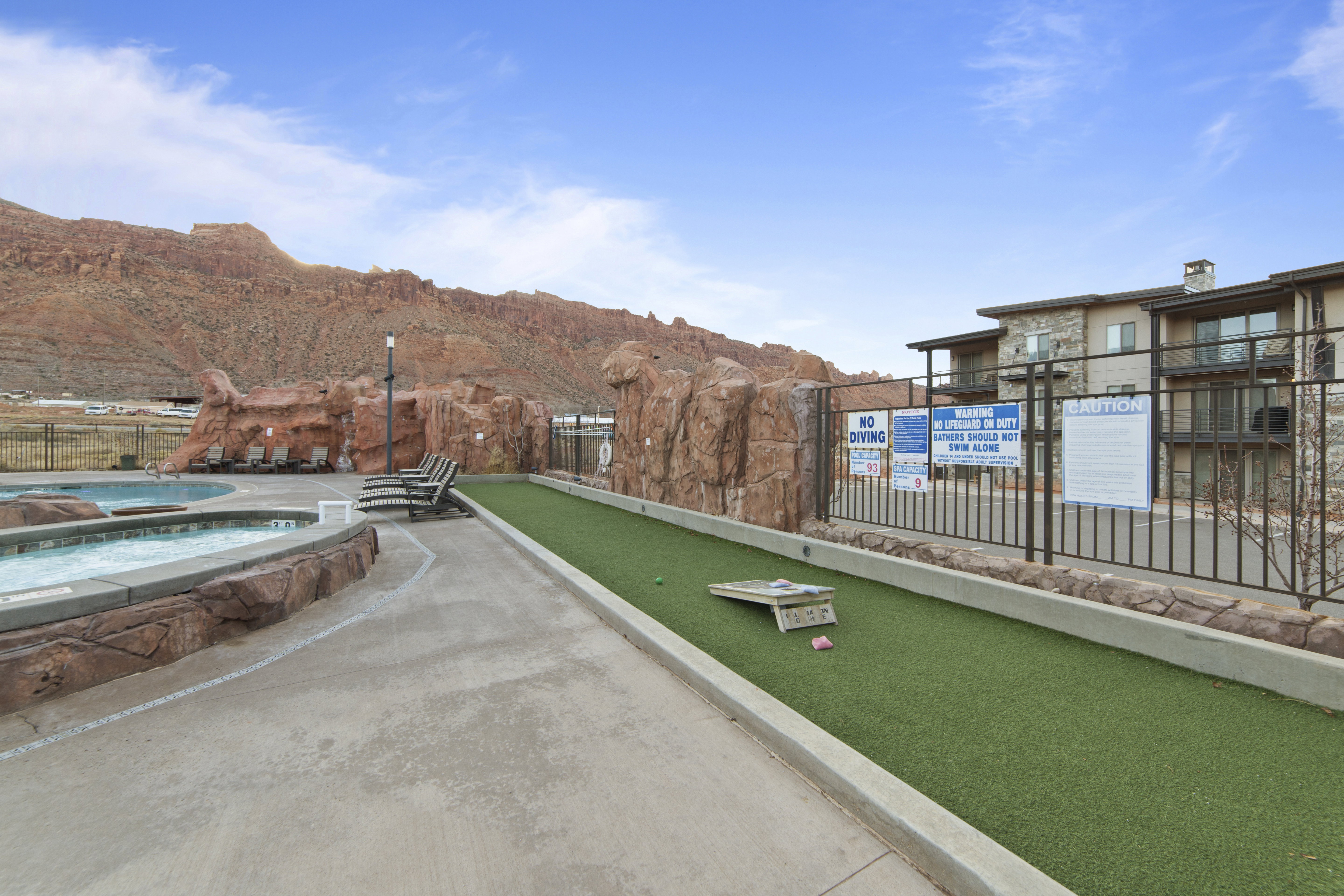 View of property's community with a game area, a jacuzzi, and a mountain view