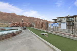 View of property's community with a game area, a jacuzzi, and a mountain view