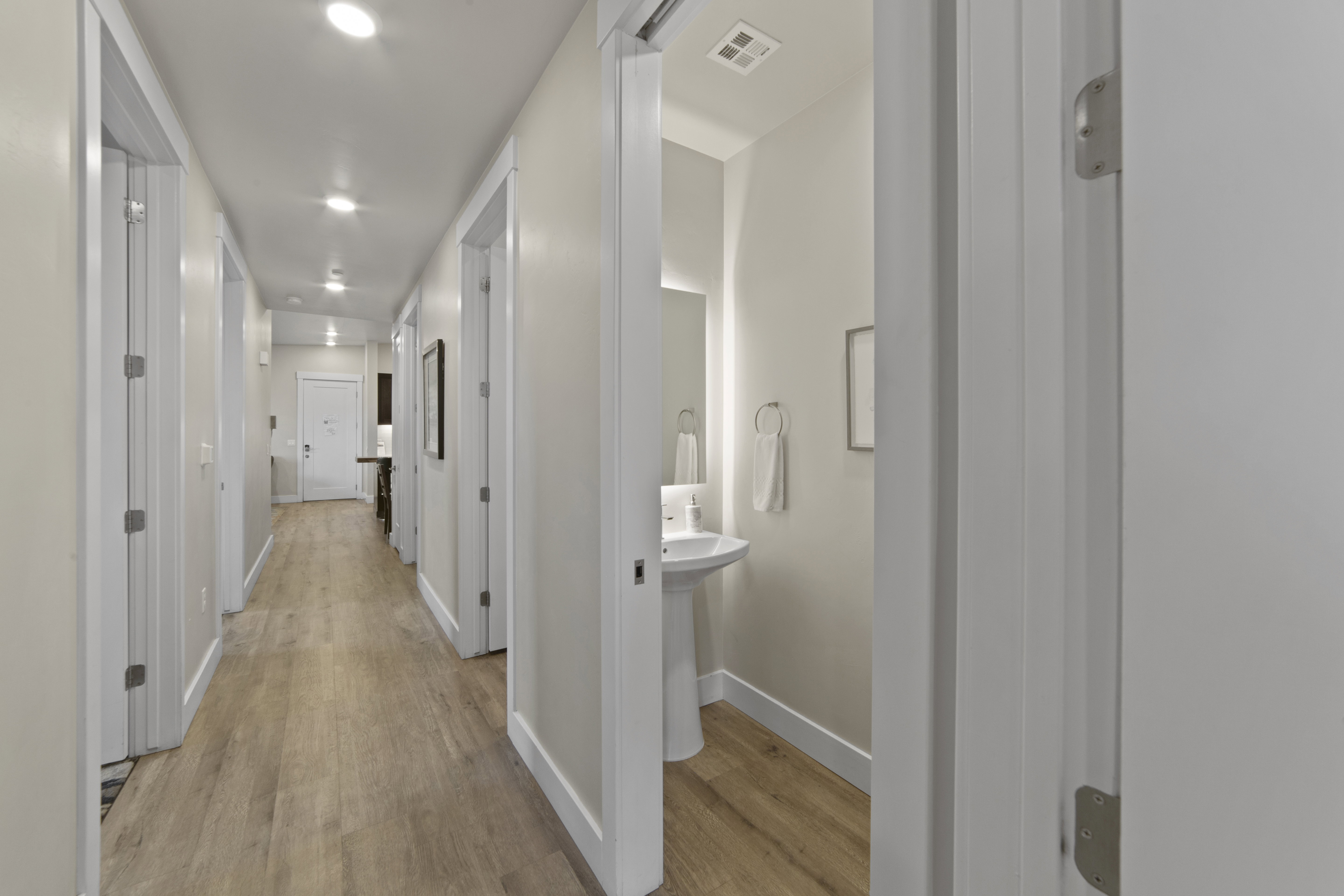 Hallway with light wood-type flooring and recessed lighting