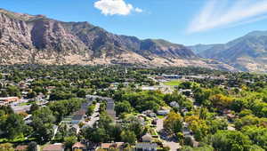 Aerial perspective of suburban area with a mountain backdrop and a tree filled landscape