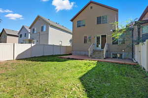 Back of property with a fenced backyard and a patio area