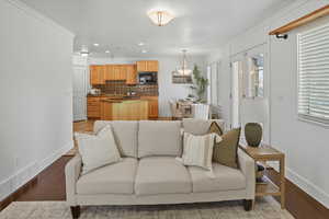 Living room with crown molding, light wood finished floors, and recessed lighting