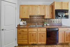 Kitchen featuring light brown cabinetry and decorative backsplash