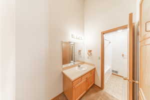 Jack and Jill bathroom with separate vanities. One door to hall, one door into primary bedroom.