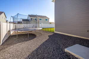 Fenced backyard with a trampoline