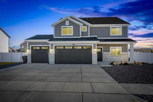 Craftsman-style home featuring board and batten siding, brick siding, driveway, a porch, and an attached garage