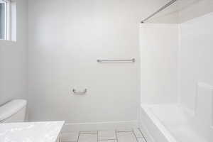 Bathroom with light tile patterned floors, shower / tub combination, and vanity