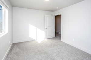 Carpeted empty room featuring baseboards