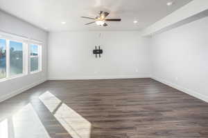 Empty room with ceiling fan, dark wood finished floors, and recessed lighting