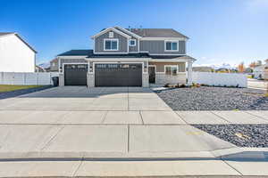 View of front facade with board and batten siding, driveway, a shingled roof, and a garage