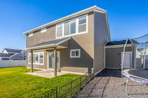Rear view of house with a patio, stucco siding, and a trampoline