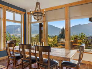 Dining space with a mountain view, wood finished floors, and a chandelier